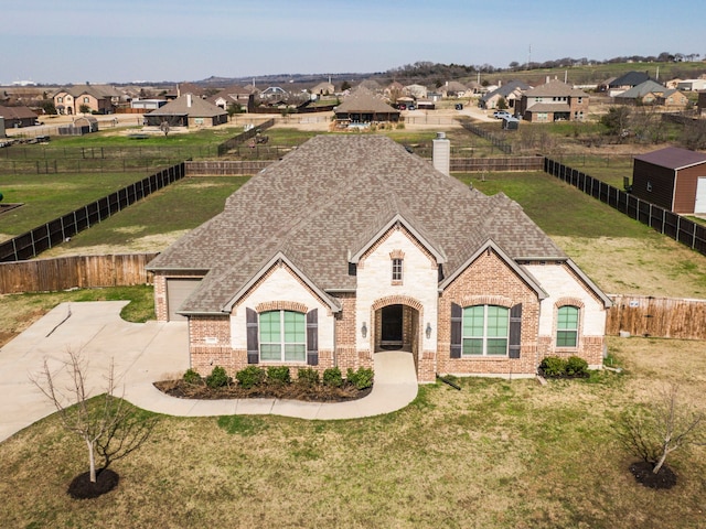 french country style house with roof with shingles, brick siding, a front lawn, and a residential view