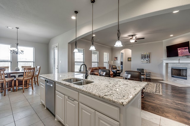 kitchen with pendant lighting, open floor plan, white cabinetry, a sink, and an island with sink