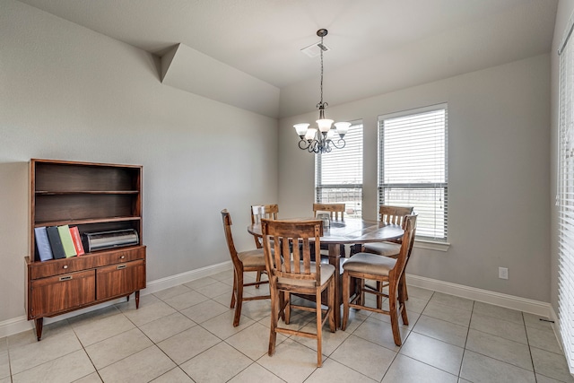 dining room with a chandelier, light tile patterned flooring, vaulted ceiling, and baseboards