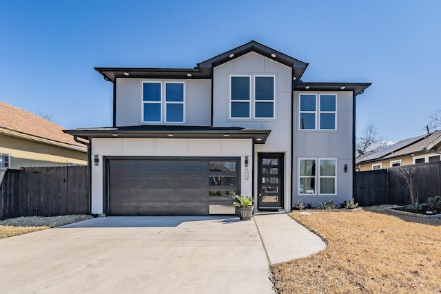 contemporary home with a garage, board and batten siding, fence, and concrete driveway