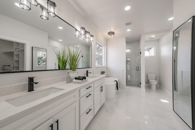 full bath with a stall shower, marble finish floor, a sink, and recessed lighting