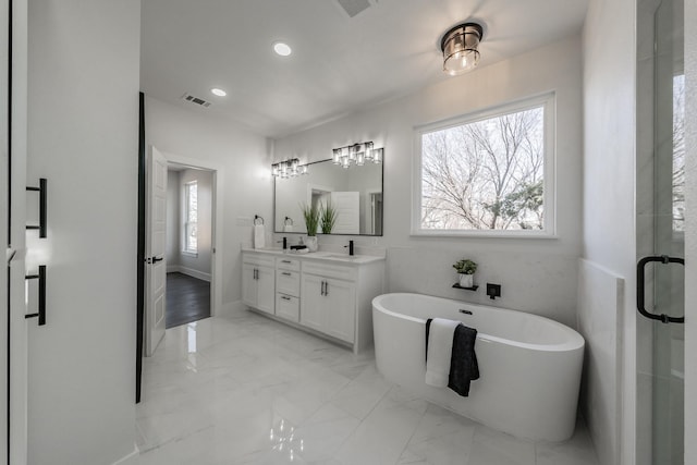 full bathroom with marble finish floor, a soaking tub, visible vents, a sink, and plenty of natural light