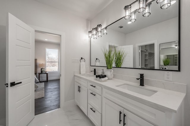 bathroom featuring double vanity, baseboards, visible vents, and a sink