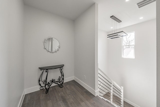 hallway with baseboards, visible vents, dark wood-type flooring, and recessed lighting