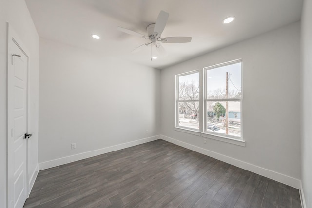 spare room featuring a ceiling fan, recessed lighting, dark wood finished floors, and baseboards