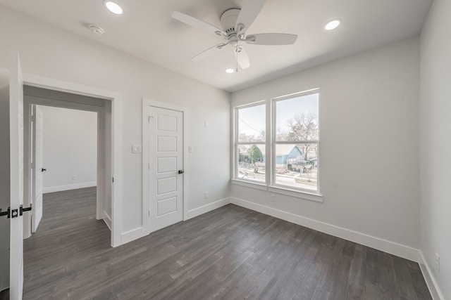 unfurnished bedroom with recessed lighting, dark wood-style flooring, and baseboards