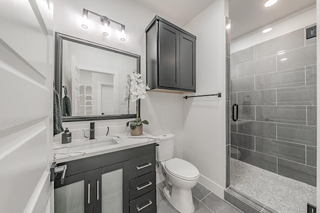 full bathroom featuring toilet, a shower stall, vanity, baseboards, and tile patterned floors