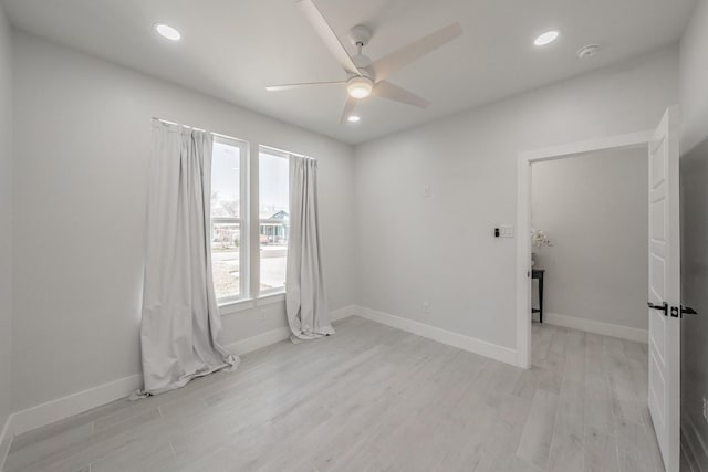 empty room with ceiling fan, recessed lighting, light wood-type flooring, and baseboards