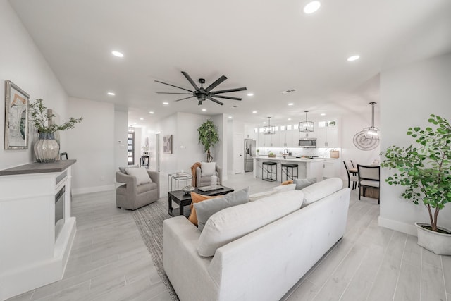 living room with light wood-style floors, recessed lighting, a chandelier, and visible vents