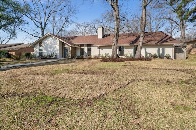 view of front facade with a front lawn, a chimney, and brick siding