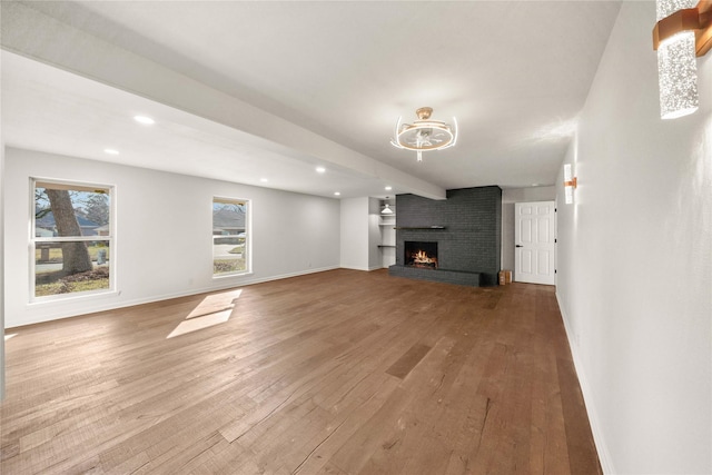 3829 Cloverdale Dr, Tyler, TX 75701 - unfurnished living room with hardwood / wood-style floors, baseboards, a fireplace, and recessed lighting