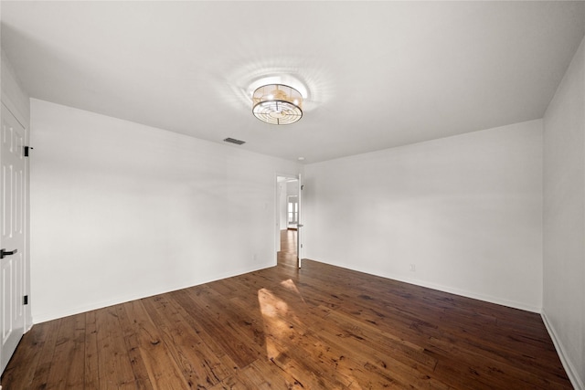 3829 Cloverdale Dr, Tyler, TX 75701 - spare room featuring dark wood-style flooring, baseboards, and a chandelier