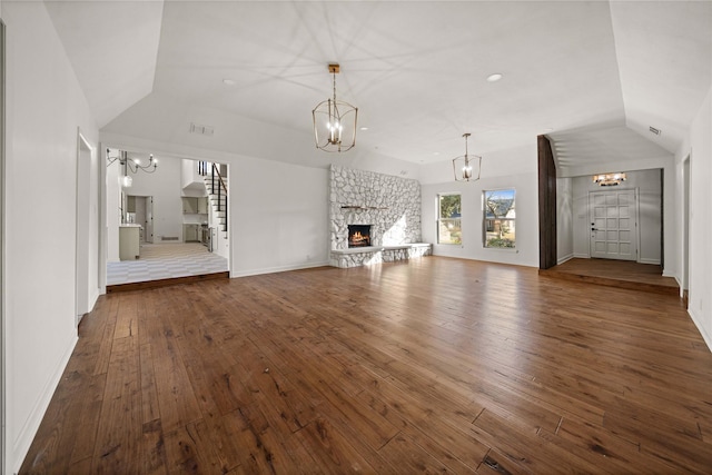 3829 Cloverdale Dr, Tyler, TX 75701 - unfurnished living room featuring a chandelier, vaulted ceiling, dark wood-style floors, a fireplace, and baseboards
