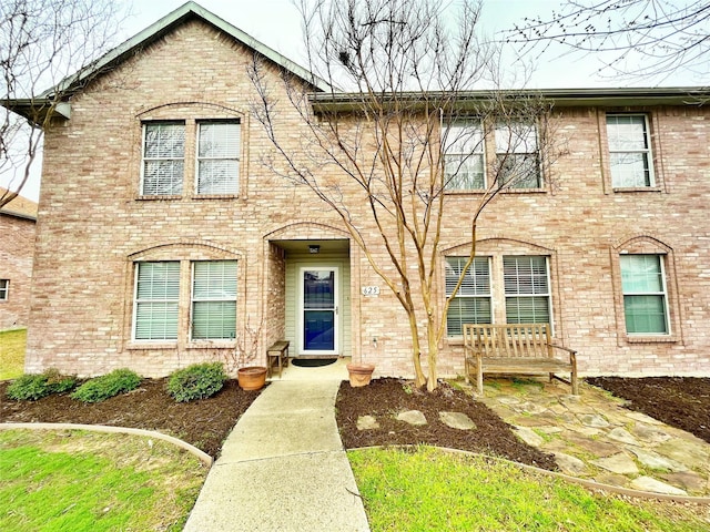 view of front facade featuring a patio and brick siding