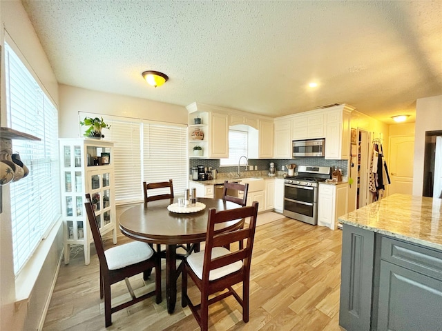 dining room featuring light wood-style flooring and a textured ceiling