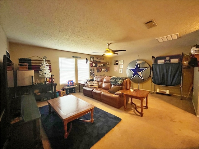 living area featuring carpet, visible vents, ceiling fan, and a textured ceiling