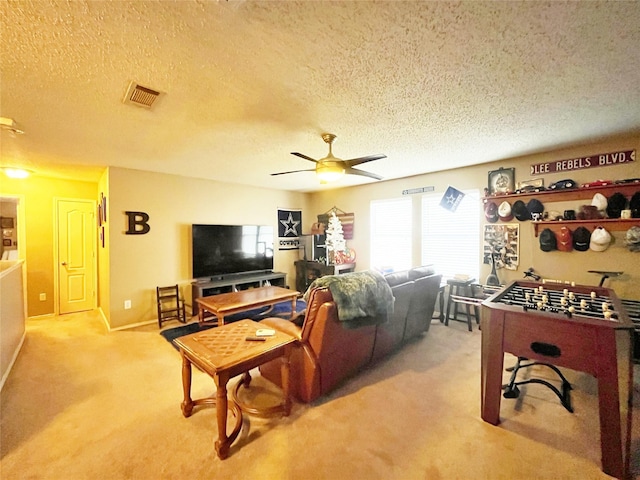 living room featuring ceiling fan, baseboards, visible vents, and light colored carpet