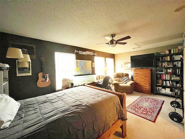 carpeted bedroom with a ceiling fan and a textured ceiling