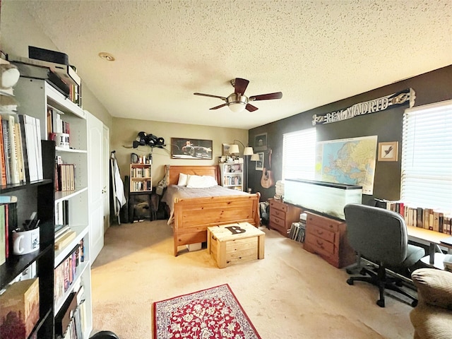 carpeted bedroom featuring a ceiling fan and a textured ceiling