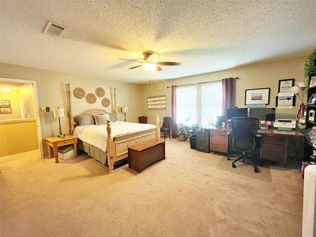 bedroom featuring ceiling fan, a textured ceiling, visible vents, and light colored carpet