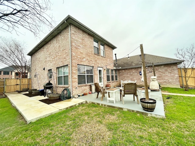 rear view of house with an outdoor fire pit, a patio area, fence, and brick siding