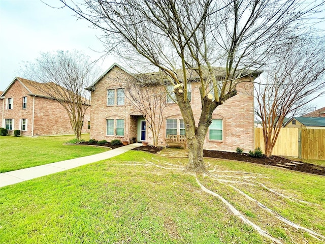 view of front of house with fence, a front lawn, and brick siding