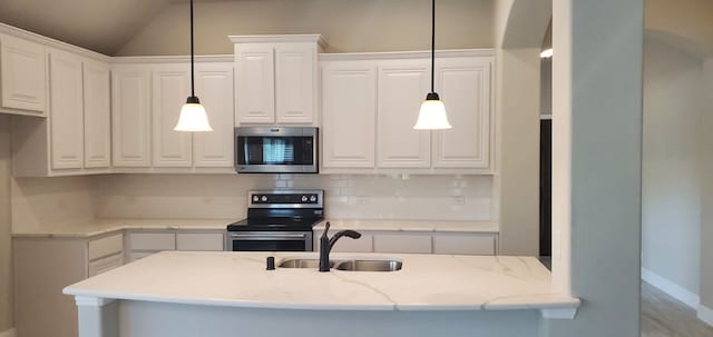 kitchen featuring hanging light fixtures, appliances with stainless steel finishes, and white cabinets