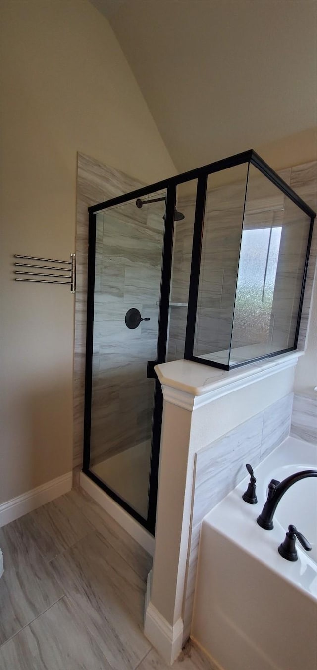 full bath featuring lofted ceiling, a shower stall, and a bath