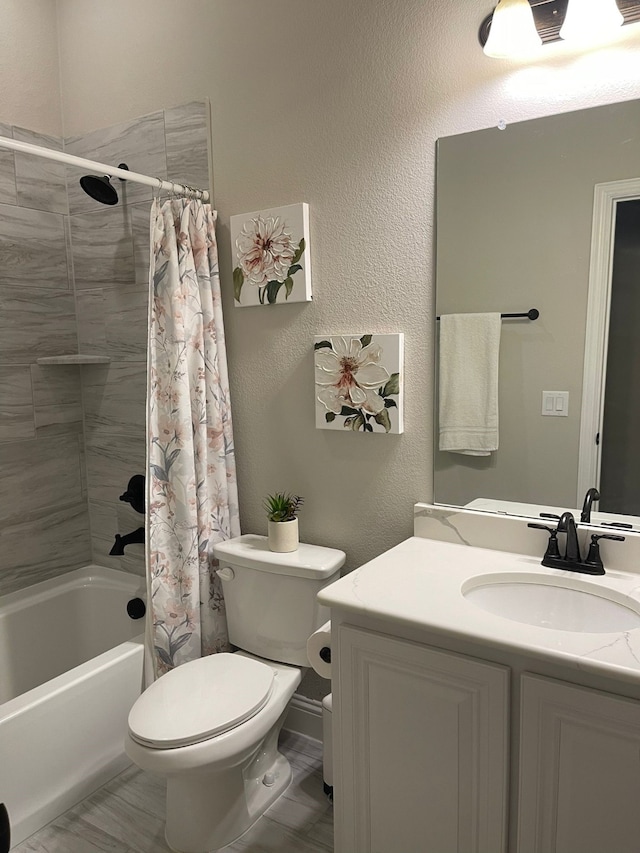 bathroom featuring toilet, a textured wall, shower / tub combo with curtain, and vanity