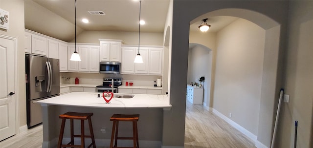 kitchen with hanging light fixtures, appliances with stainless steel finishes, and white cabinetry