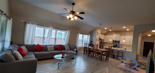 living room featuring lofted ceiling, ceiling fan, arched walkways, and recessed lighting