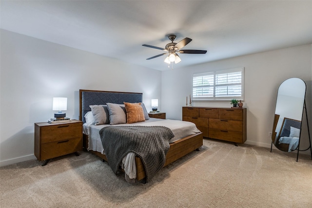 bedroom featuring light carpet, ceiling fan, and baseboards