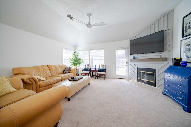 living room with a large fireplace, light carpet, vaulted ceiling, and a textured ceiling