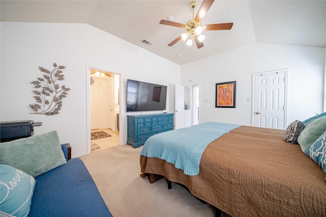 bedroom featuring light colored carpet, visible vents, a ceiling fan, vaulted ceiling, and connected bathroom