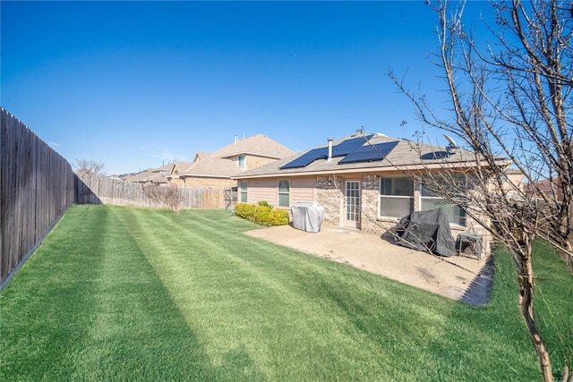 back of property with a patio, a lawn, and a fenced backyard