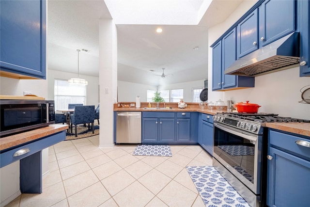 kitchen with stainless steel appliances, pendant lighting, blue cabinets, and under cabinet range hood