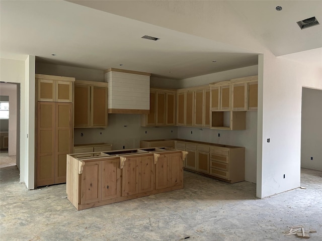 kitchen with a center island, visible vents, and wall chimney range hood