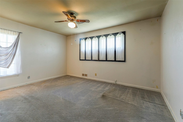 spare room featuring a ceiling fan, baseboards, visible vents, and carpet flooring