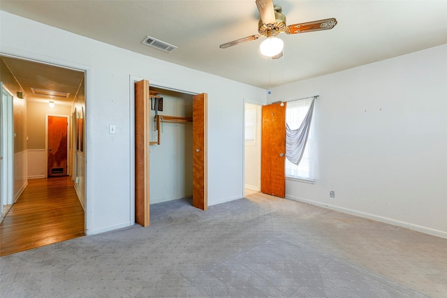 unfurnished bedroom with ceiling fan, carpet flooring, visible vents, a closet, and attic access