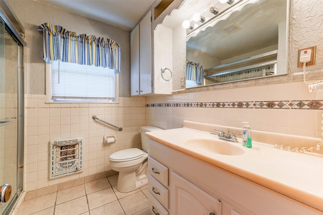 bathroom with vanity, tile patterned flooring, a shower with shower door, and heating unit