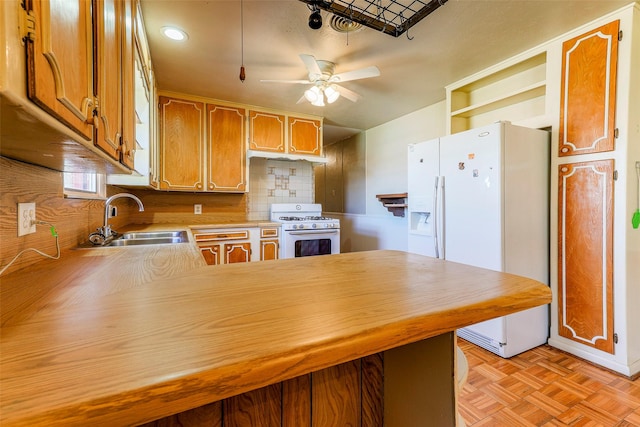 kitchen featuring open shelves, light countertops, a sink, white appliances, and a peninsula