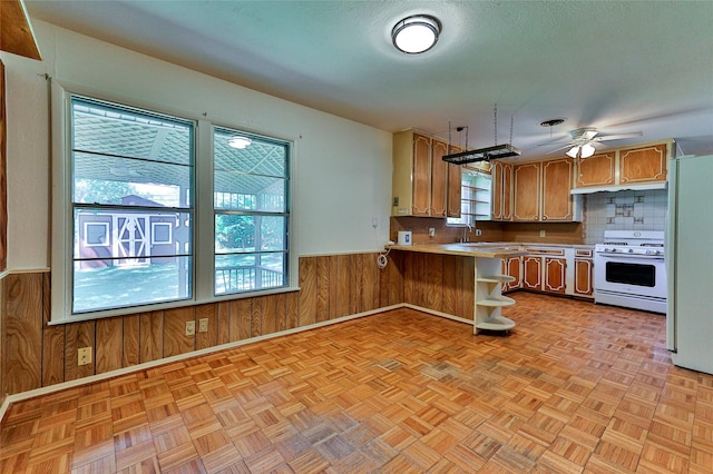205 Bedford Ct E, Bedford, TX 76022 - kitchen featuring plenty of natural light, wooden walls, white appliances, and a peninsula