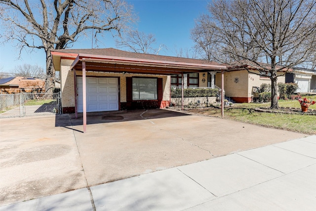 exterior space with brick siding, driveway, an attached garage, and fence