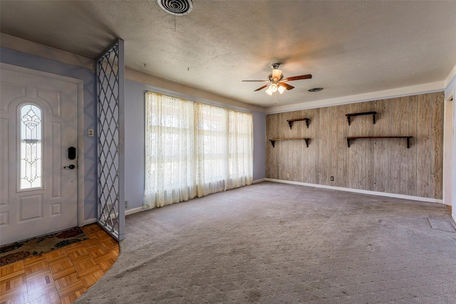 foyer entrance with a ceiling fan, visible vents, a textured ceiling, and baseboards