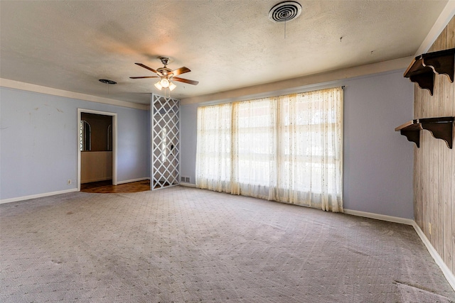 carpeted empty room with visible vents, ceiling fan, and a textured ceiling