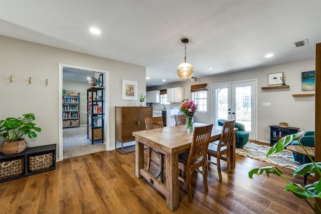 dining space with french doors, wood finished floors, visible vents, and recessed lighting