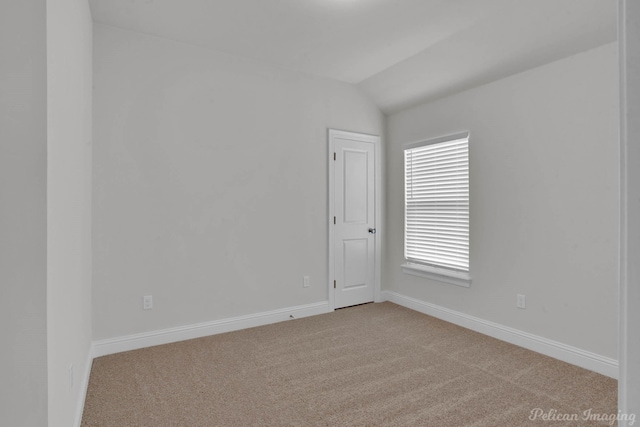 unfurnished room with light carpet, baseboards, and lofted ceiling