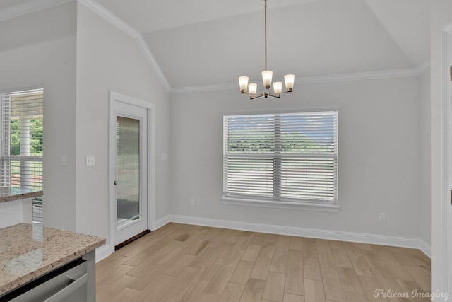 unfurnished dining area with light wood finished floors, vaulted ceiling, crown molding, and an inviting chandelier