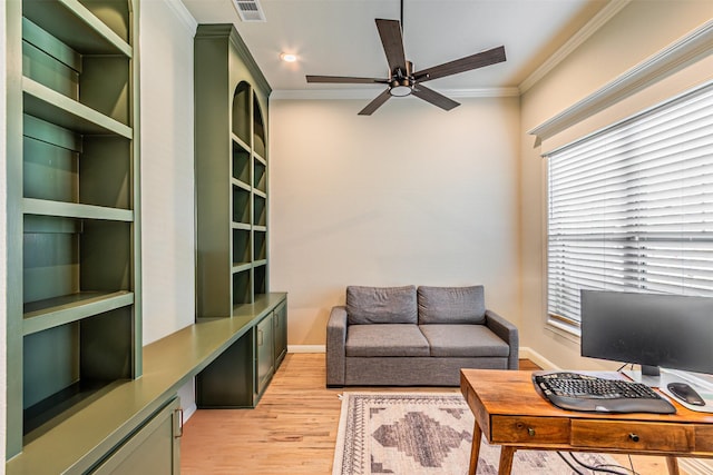 office space with ceiling fan, light wood-style flooring, visible vents, built in study area, and crown molding