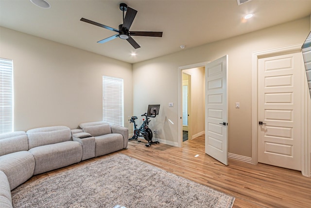 living area featuring baseboards, recessed lighting, a ceiling fan, and light wood-style floors